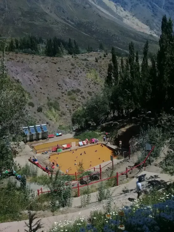 Vista elevada de una piscina termal entre árboles y montañas